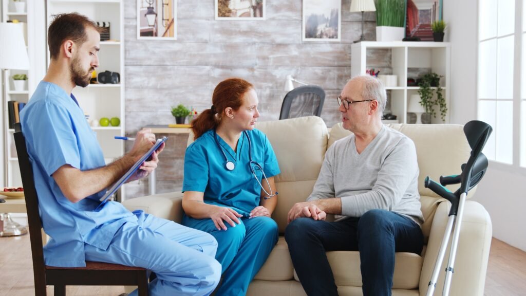 Team of male and female nurses talking with an old and retired man